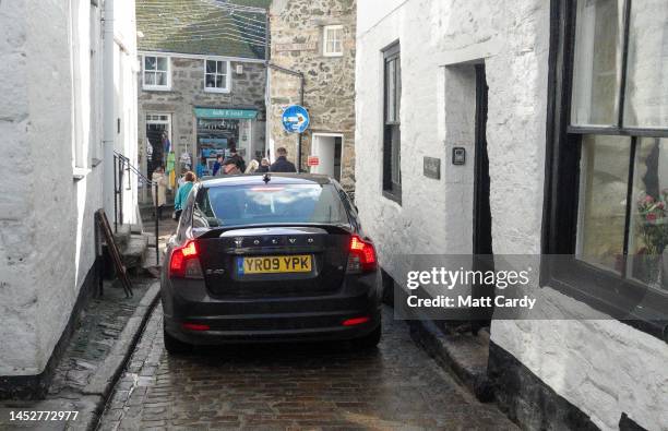 Car tries to navigate through the narrow historic streets at St Ives on October 27, 2022 in Cornwall, England. The county of Cornwall, in the south...