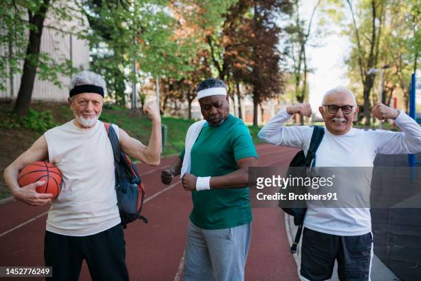 multiracial group of senior men showing off their muscles on exercise court - body confidence stock pictures, royalty-free photos & images