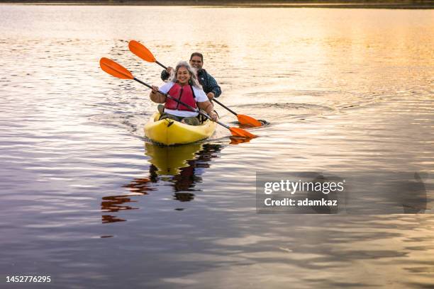 senior hispanic couple kayaking - older person kayaking stock pictures, royalty-free photos & images