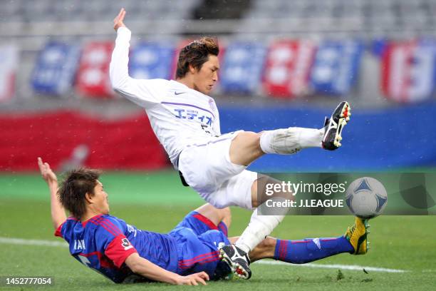 Toshihiro Aoyama of Sanfrecce Hiroshima is tackled by Kenichi Kaga of FC Tokyo during the J.League J1 match between FC Tokyo and Sanfrecce Hiroshima...