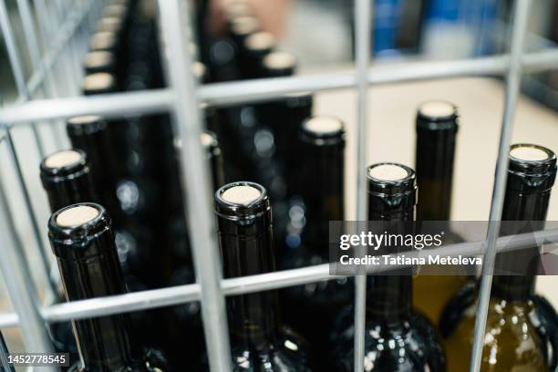 close up of iron storage basket with wine bottles - iron wine stock pictures, royalty-free photos & images