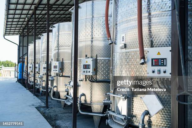 winemaking plant, cellar. metal vats in the storage - vorratstank stock-fotos und bilder