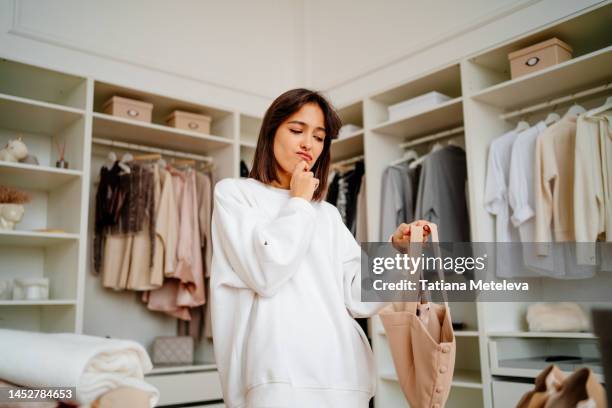 slimming underwear buying.  confused woman thinking and choosing new top and slimming underwear in the clothes store - the human body photos et images de collection