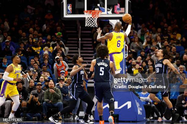 LeBron James of the Los Angeles Lakers lays the ball up against the Orlando Magic during the first quarter at Amway Center on December 27, 2022 in...