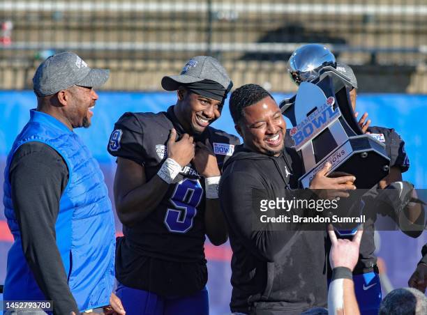 Logic Hudgens is all smiles as head coach Maurice Linguist of the Buffalo Bulls hoist the Camelia Bowl Trophy during post game celebration of the the...