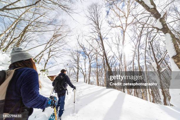 two people snow shoe hiking in winter forest - snowshoeing stock pictures, royalty-free photos & images