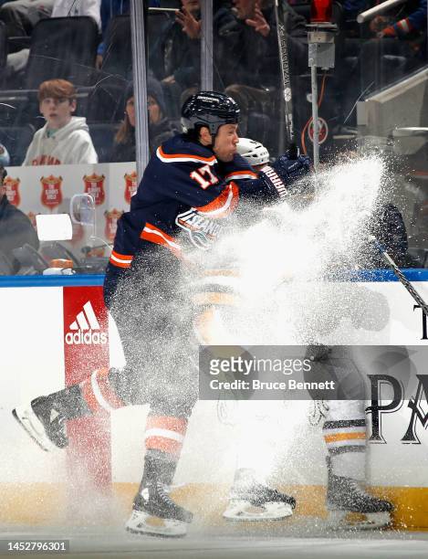 Matt Martin of the New York Islanders checks Jan Rutta of the Pittsburgh Penguins into the boards during the first period at the UBS Arena on...