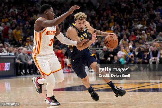 Chris Duarte of the Indiana Pacers dribbles the ball while being guarded by Aaron Holiday of the Atlanta Hawks in the first quarter at Gainbridge...