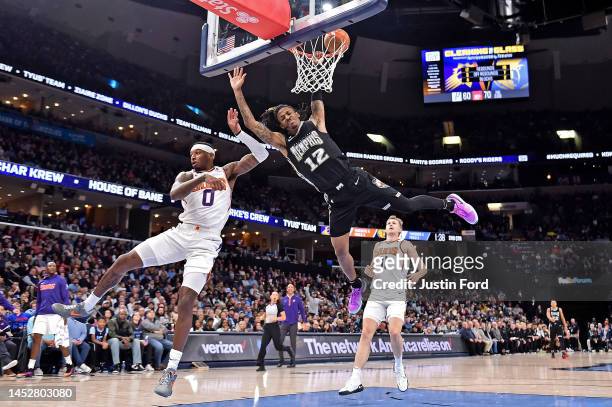 Ja Morant of the Memphis Grizzlies attempts to dunk during the first half against Torrey Craig of the Phoenix Suns at FedExForum on December 27, 2022...