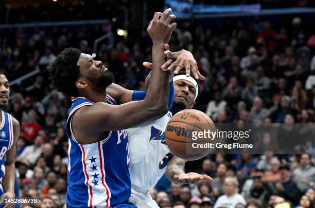 Bradley Beal of the Washington Wizards battles for the ball in the fourth quarter against Joel Embiid of the Philadelphia 76ers at Capital One Arena...