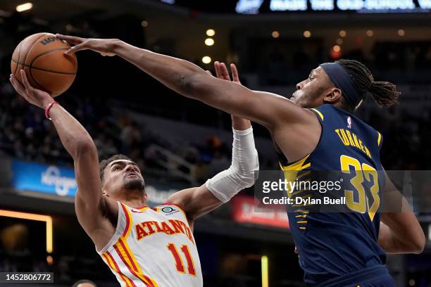 Trae Young of the Atlanta Hawks attempts a shot while being guarded by Myles Turner of the Indiana Pacers in the third quarter at Gainbridge...