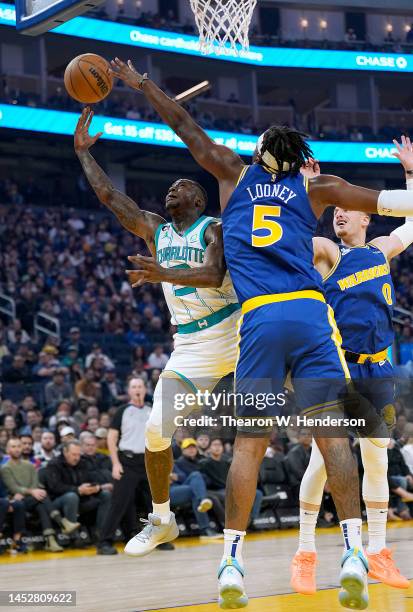 Terry Rozier of the Charlotte Hornets shoots over Kevon Looney of the Golden State Warriors during the first quarter at Chase Center on December 27,...