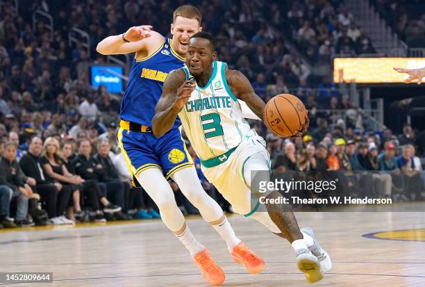 Terry Rozier of the Charlotte Hornets drives to the basket past Donte DiVincenzo of the Golden State Warriors during the first quarter at Chase...