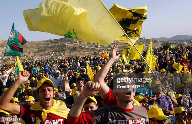 Lebanese Hezbollah supporters wave the yellow flag of their party during a rally in the southern town of Bint Jbeil on May 25, 2012 to mark the 12th...