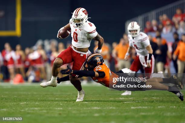 Safety Jason Taylor II of the Oklahoma State Cowboys tackles running back Braelon Allen of the Wisconsin Badgers during the first half of the...