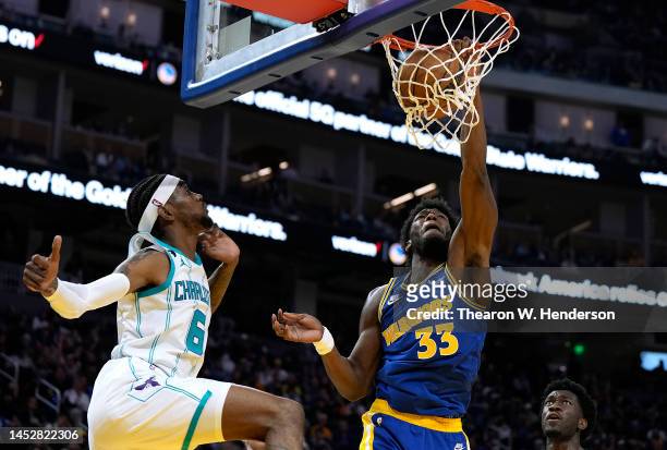 James Wiseman of the Golden State Warriors slam dunks over Jalen McDaniels of the Charlotte Hornets during the fourth quarter at Chase Center on...