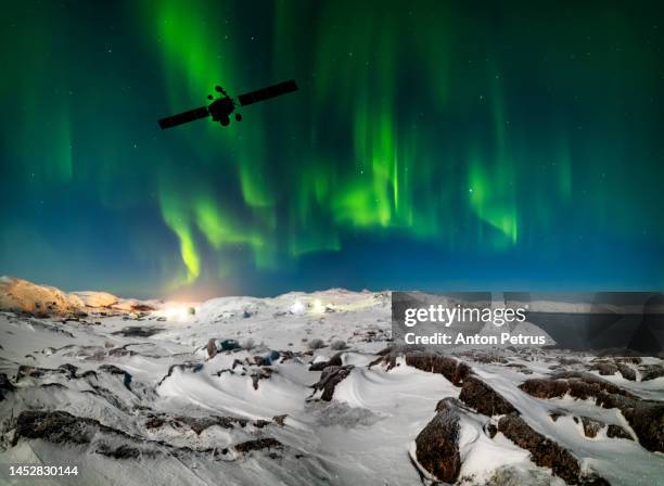 communications satellite on the background of the northern lights - satellite dish foto e immagini stock