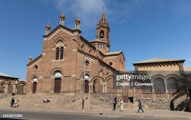 Pedestrians walk in front of the Cathedral Our Lady of the Rosary Catholic Church on Harnet Avenue in the city center on December 27, 2022 in Asmara,...