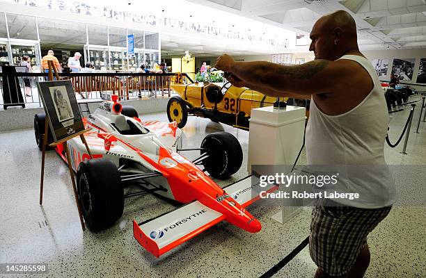 Race fan Jacquie Coy takes a picture of Dan Wheldon's William Rast-Curb/Big Machine Dallara Honda of 2011 Indianapolis 500 winner Dan Wheldon of...