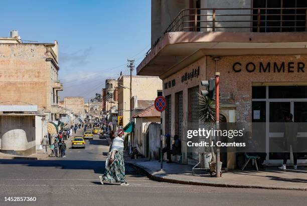 Pedestrians walk past buildings that line Harnet Avenue in the city center on December 27, 2022 in Asmara, Eritrea. Asmara was originally constructed...