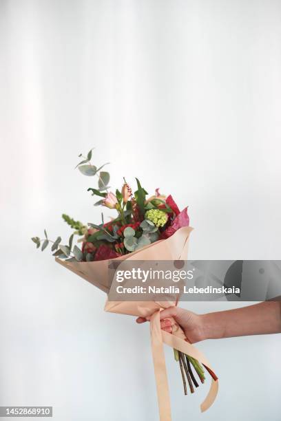 hand holding bouquet of flowers. vertical and copy space. - bouquet fiori foto e immagini stock