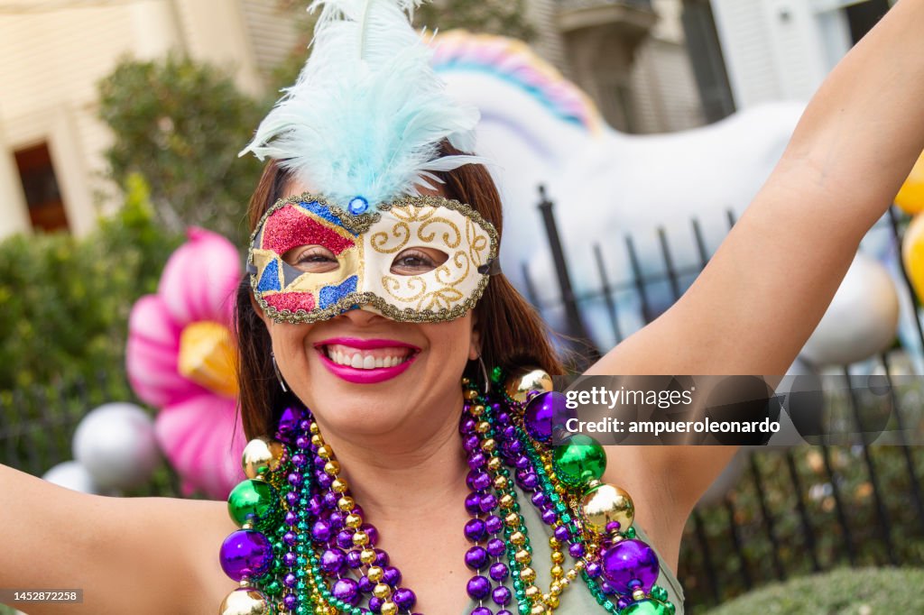 Une jeune touriste latine, portant un masque, des costumes et des colliers célébrant Mardi Gras dans les rues de la Nouvelle-Orléans.