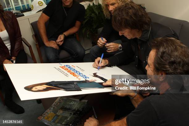 The members of Bon Jovi signing memorbilia backstage on a TV program on December 18, 2008 in New York City.