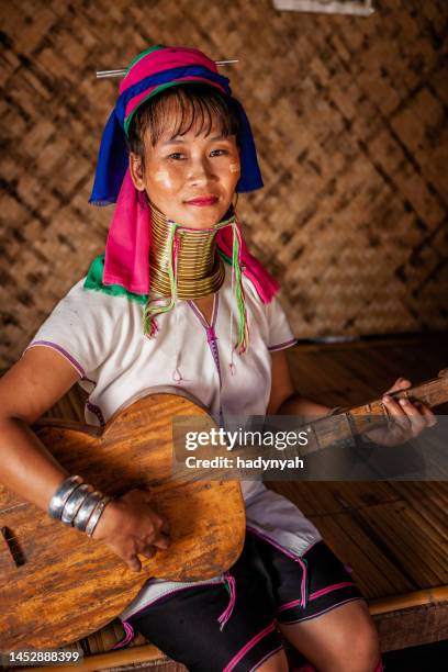 young woman from long neck karen tribe playing guitar, northern thailand - padaung tribe stock pictures, royalty-free photos & images