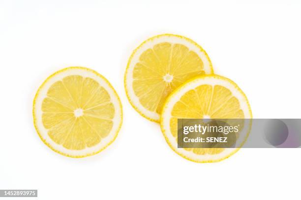 close-up of lemon slice against white background - lemon slice stock pictures, royalty-free photos & images