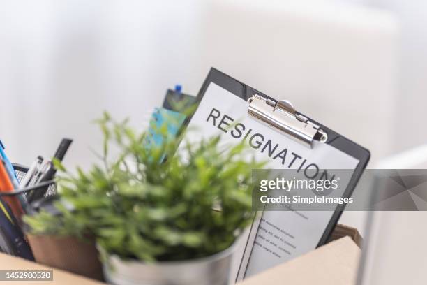 a box full of personal items with a notice of termination of employment. - employee retention stock pictures, royalty-free photos & images