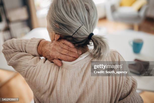 old woman has neck problems - neck pain stock pictures, royalty-free photos & images