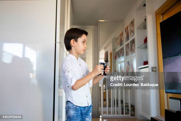 kid playing with gamepad at hom - hom stock pictures, royalty-free photos & images