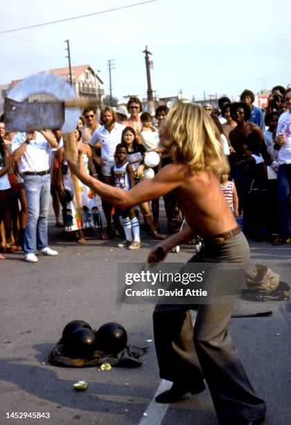 Street performer juggles a hatchet, a machete, and a scythe in Muscle Beach, the birthplace of the fitness and bodybuilding craze, in September, 1979...