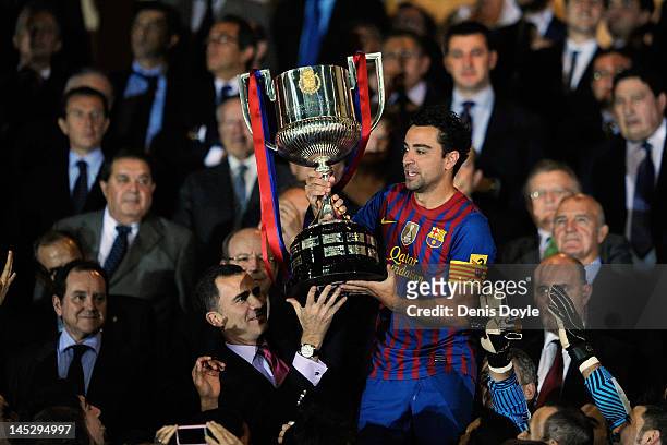Xavi Hernandez of Barcelona is handed the Copa del Rey trophy by Prince Felipe after beating Athletic Bilbao 3-0 during the Copa del Rey Final at...