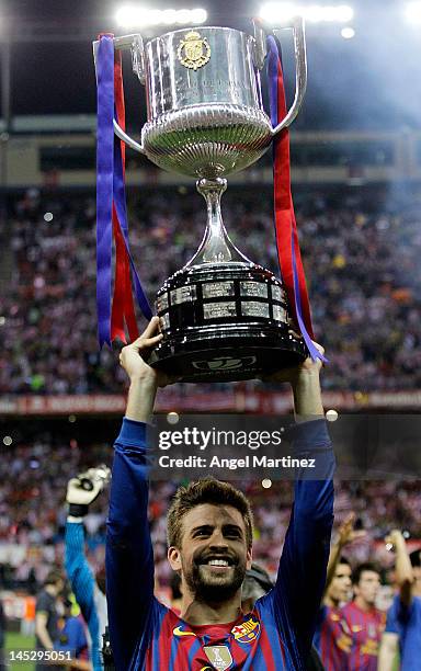 Gerard Pique of Barcelona holds the trophy in celebration after their victory in the Copa del Rey Final match between Athletic Bilbao and Barcelona...