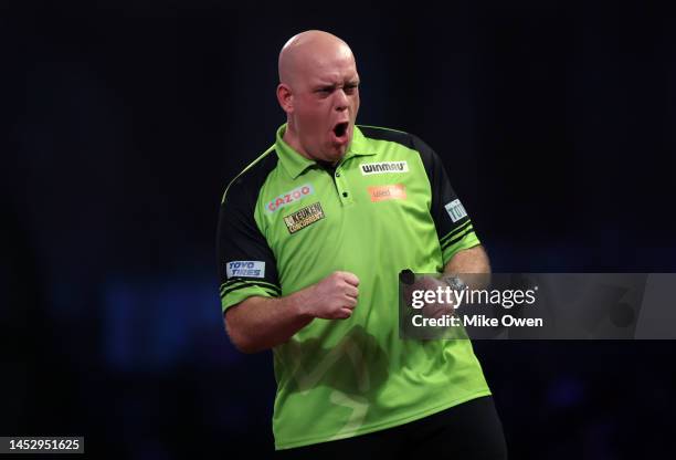 Michael van Gerwen of Netherlands celebrates after winning the first set during his Third Round match against Mensur Suljovic of Serbia during Day...