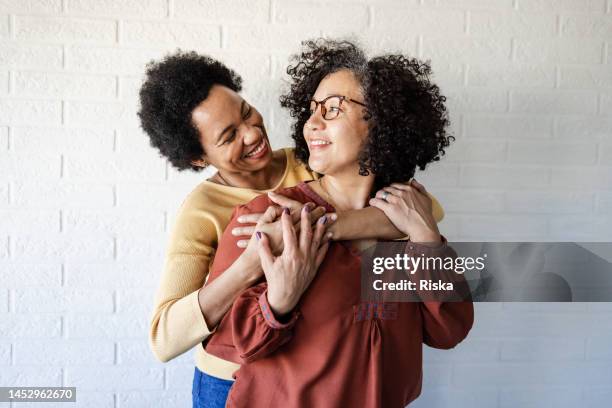 portrait of two lesbian women hugging - lgbtqia culture stock pictures, royalty-free photos & images
