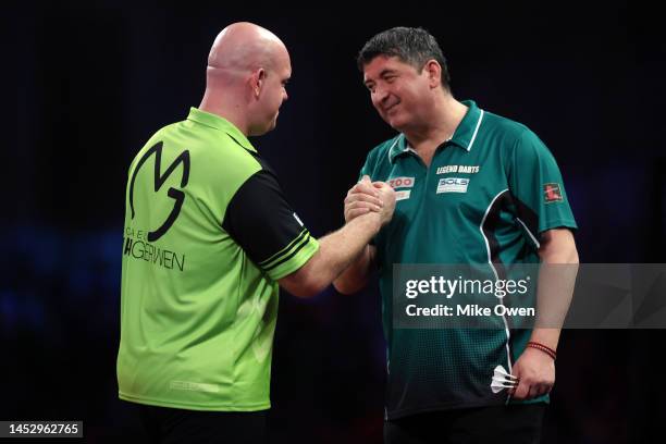 Michael van Gerwen of Netherlands and Mensur Suljovic of Serbia shake hands following their Third Round match during Day Nine of The Cazoo World...