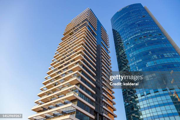 low angle view of modern office towers against blue sky - tel aviv stock-fotos und bilder