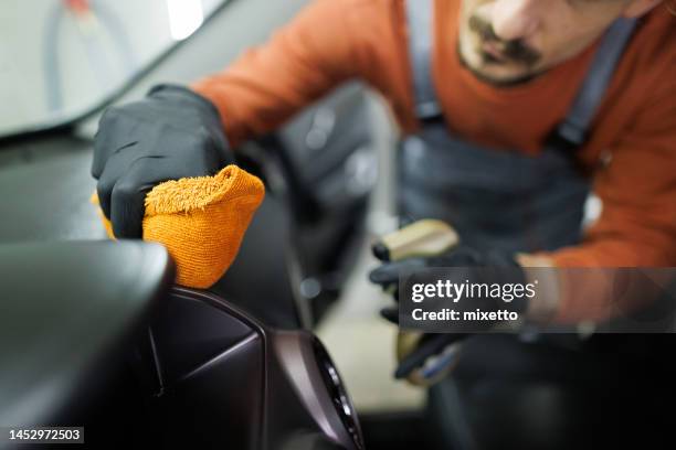 close up shot of professional car detailer cleaning car interior with a microfiber towerl - auto cockpit bildbanksfoton och bilder