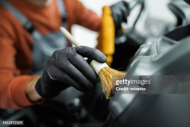 close up shot of professional car detailer cleaning car interior with a brush - car detailing stock pictures, royalty-free photos & images