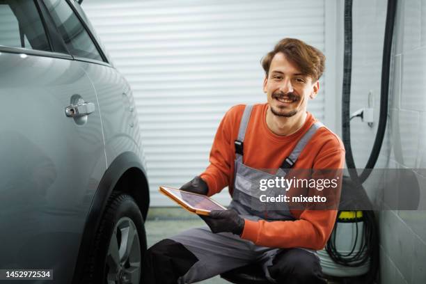portrait of young handsome car detailer at his small garage - car detailing stock pictures, royalty-free photos & images