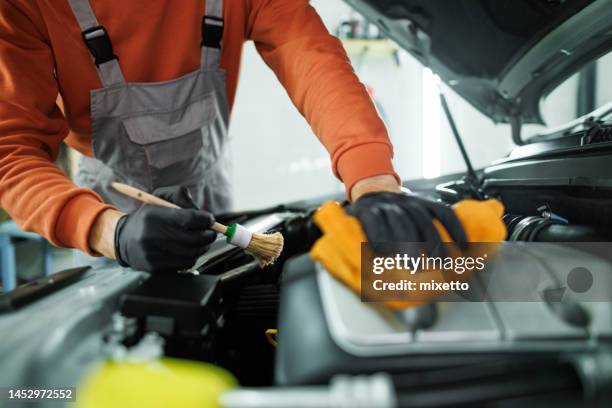 close up shot of professional car detailer cleaning car engine space with a brush and microfiber towel - microfiber towel stock pictures, royalty-free photos & images