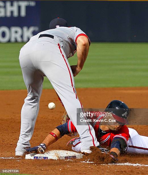 Martin Prado of the Atlanta Braves slides safely into third base under Ryan Zimmerman of the Washington Nationals in the third inning at Turner Field...