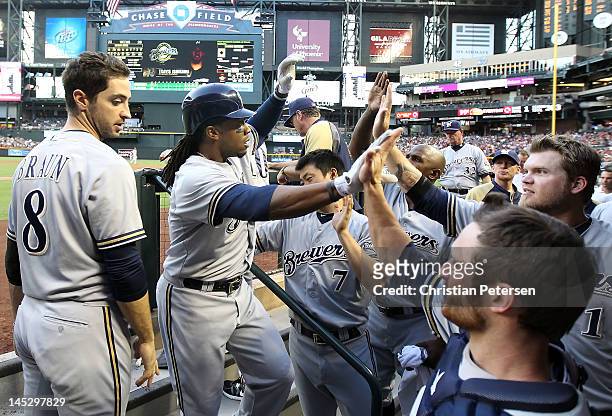 Rickie Weeks of the Milwaukee Brewers high-fives Jonathan Lucroy and Corey Hart in the dugout after Weeks hit a solo home run against the Arizona...