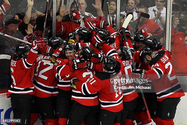 The New Jersey Devils celebrate after the game winning goal by Adam Henrique in overtime against the New York Rangers to win Game Six of the Eastern...