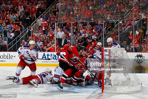 Adam Henrique of the New Jersey Devils scores a game winning goal in overtime against Henrik Lundqvist of the New York Rangers to win Game Six of the...