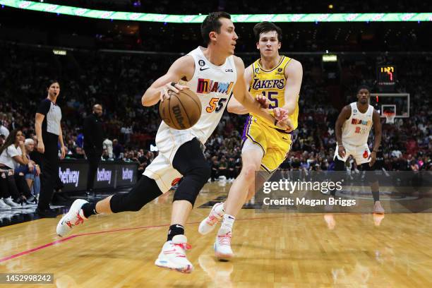 Duncan Robinson of the Miami Heat dribbles the ball past Austin Reaves of the Los Angeles Lakers during the second quarter of the game at FTX Arena...