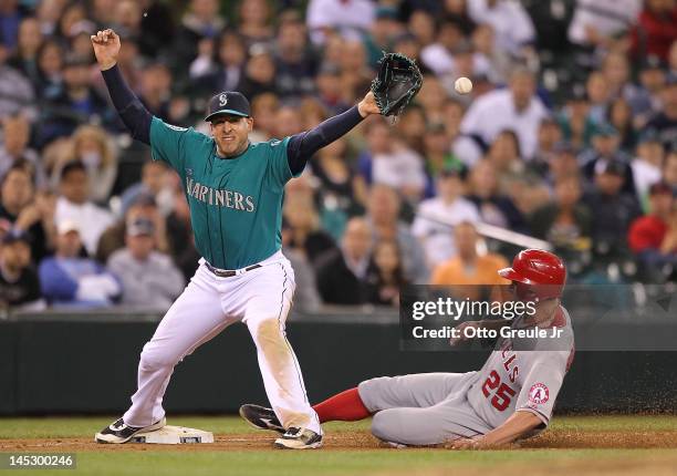 Third baseman Alex Liddi of the Seattle Mariners can't handle the throw from closing pitcher Brandon League on a force out attempt in the ninth...