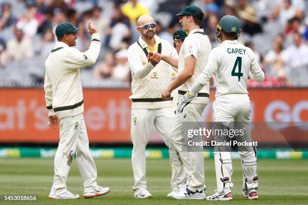 Nathan Lyon of Australia celebrates with Pat Cummins of Australia after combining to dismiss Kagiso Rabada of South Africa during day four of the...